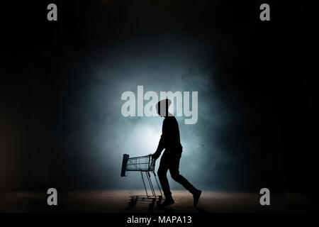 Jeune mâle dans un dessin clothers occasionnels Panier vide dans la rue Banque D'Images