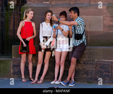 Deux jeunes filles, femme d'âge moyen et l'homme à la recherche de leur téléphone cellulaire, Strasbourg, Alsace, France, Europe, Banque D'Images