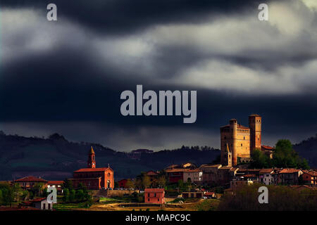 Un rayon de soleil illumine le château et l'église de Serralunga d'Alba sous un ciel d'orage. Nous sommes au centre de la zone de production du Barolo. Banque D'Images