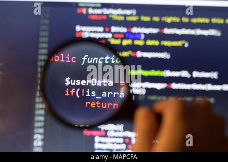 PHP code d'arrière-plan par le biais d'un zoom de la loupe. Le code source de programmation de l'ordinateur recherche. L'écran Résumé de développeur web. Banque D'Images