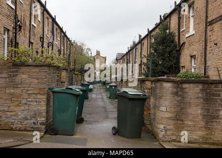 Retour à l'arrière des maisons mitoyennes avec des poubelles à la disposition de la Victorian village modèle de Saltaire, West Yorkshire Banque D'Images