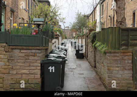 Retour à l'arrière des maisons mitoyennes avec des poubelles à la disposition de la Victorian village modèle de Saltaire, West Yorkshire Banque D'Images