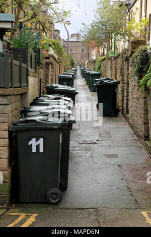 Retour à l'arrière des maisons mitoyennes avec des poubelles à la disposition de la Victorian village modèle de Saltaire, West Yorkshire Banque D'Images