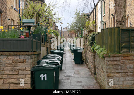 Retour à l'arrière des maisons mitoyennes avec des poubelles à la disposition de la Victorian village modèle de Saltaire, West Yorkshire Banque D'Images