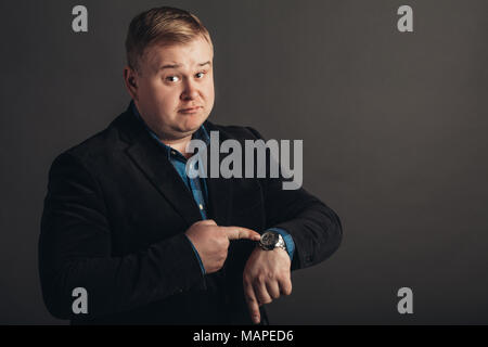 Surpris fat man qui regarde sa montre. Banque D'Images