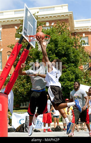 Un jeune homme s'élance vers le panier contre un défenseur, dans un 3-SUR-3 qui a eu lieu le tournoi de basket-ball les rues d'Athènes, GA, le 24 août 2013. Banque D'Images