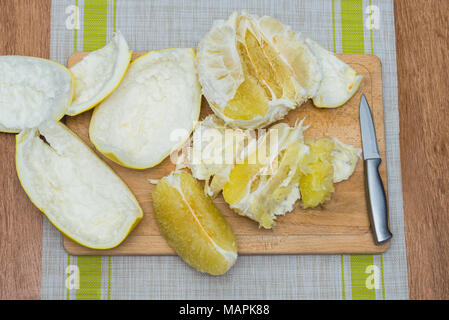 Girl cleaning ses mains avec agrumes pomelo, sur une planche en bois Banque D'Images