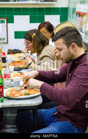 Les personnes mangeant de la pizza dans le célèbre restaurant L'Antica Pizzeria da Michele à Naples, Italie Banque D'Images