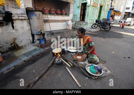 Femme faisant la journée de chapatis au feu de bois dans la rue à l'extérieur, près de la mosquée Jama dans de vieux Ahmedabad, Gujarat, Inde, Asie Banque D'Images