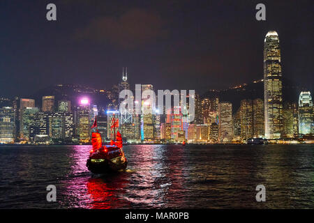 Jonque traditionnelle sur le port de Victoria avec derrière les toits de la ville illuminée la nuit, Hong Kong, Chine, Asie Banque D'Images