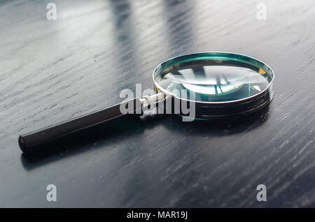 Loupe sur le dessus de table en bois noir Banque D'Images