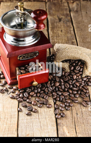 Les grains de café en sac de jute avec broyeur de café sur le bois. Banque D'Images