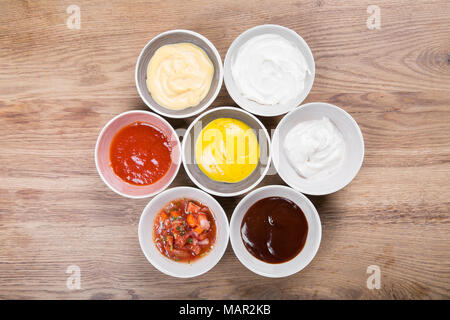 Ensemble de sauces - ketchup, mayonnaise, moutarde, sauce soja, sauce bbq, sauce moutarde grains et grenade sur fond de pierre ou de métal rouillé. Top v Banque D'Images