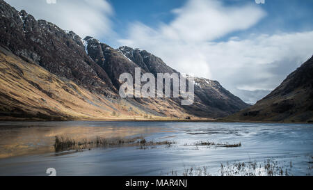 Dans Achtriochtan Loch Glencoe dans les Highlands écossais avec l'Aonach Eagach ligne de crête à l'arrière-plan Banque D'Images