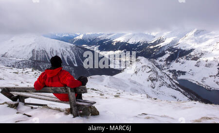 La skieuse de l'arrière-pays prend une pause et s'asseoir sur un banc au sommet et jouit de la vue de Davos en hiver Banque D'Images