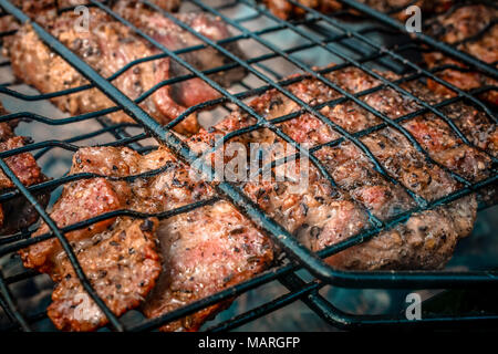 Les gros morceaux de porc frits sont sur le grill. Banque D'Images