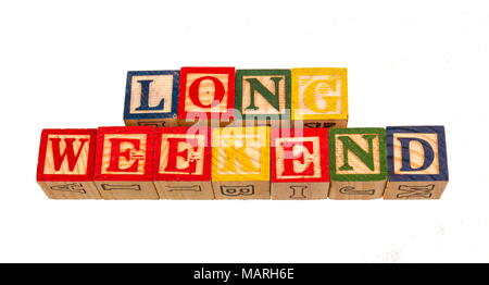 Le terme long week-end affichés sur un fond blanc à l'aide de blocs en bois coloré jouet image avec l'espace de copie au format paysage Banque D'Images