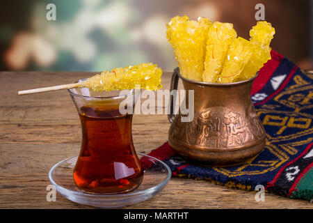 Close Up de safran sucre candy Crystal sur une tasse de thé noir est souvent utilisé pour être dissous dans le thé dans la cuisine persane iranien Banque D'Images