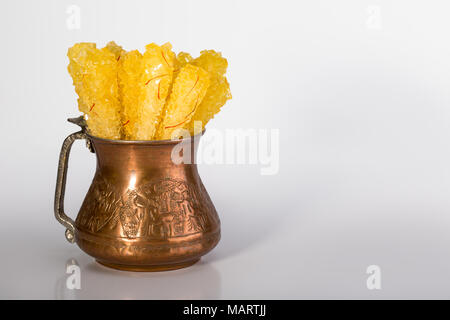 Close Up de safran sucre candy Crystal dans un bol de cuivre isolé sur fond blanc Il est souvent utilisé pour être dissous dans le thé en Iran Banque D'Images