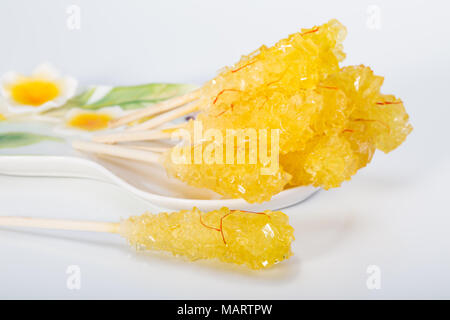 Close Up de safran sucre candy Crystal dans une assiette blanche isolé sur fond blanc Il est souvent utilisé pour être dissous dans le thé en Perse et iranienne Banque D'Images