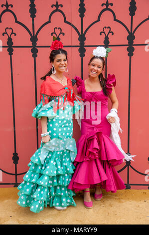 Belles jeunes femmes vêtues de robes de flamenco colorée à la foire d'Avril de Séville, Espagne Banque D'Images