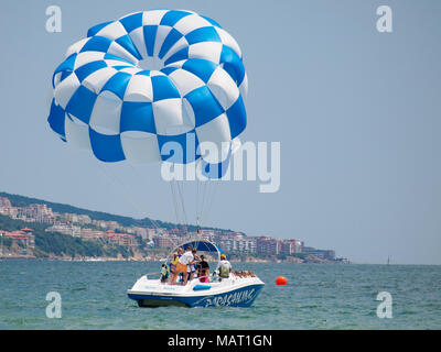 Blue wing du parachute ascensionnel tracté par un bateau dans l'eau de mer, le parapente aussi connu sous le parachute ascensionnel ou parakiting Banque D'Images