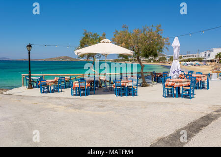 Des tables avec des chaises dans une taverne grecque typique avec vue sur la baie de la mer près de la plage d''Agia Anna, l'île de Naxos. La Grèce. Banque D'Images