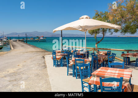 Des tables avec des chaises dans une taverne grecque typique avec vue sur la baie de la mer. Plage d'Agia Anna, l'île de Naxos. La Grèce. Banque D'Images