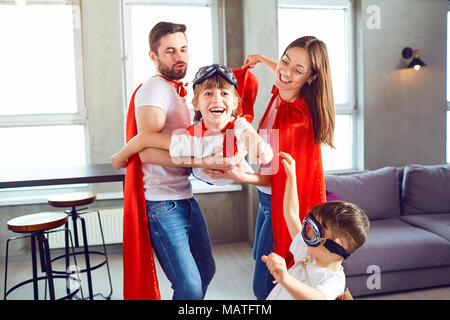 Happy Family in superhero costumes jouant ensemble. Banque D'Images