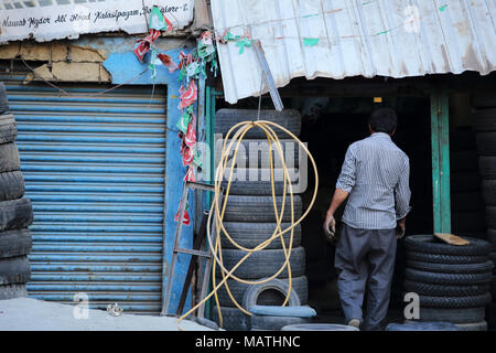 Bangalore, Inde - le 23 octobre 2016 : Un homme inconnu entrant dans sa petite boutique de pneus à Kalasipalyam Bangalore en région. Banque D'Images