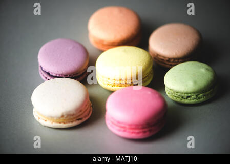 Gâteau sucré macarons français (ou macarons) avec des couleurs pastel vintage tone sur fond rose. Banque D'Images