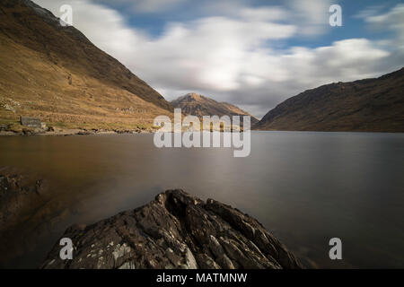 Vue sur un lac de montagne dans le proche distance, déménagement des nuages et l'eau douce avec la lumière du soleil sur la montagne Banque D'Images