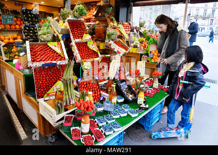 Mère et enfant devant le présentoir de vendeurs de fruits et légumes - rue des Martyrs - Paris - France Banque D'Images