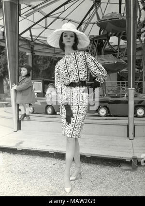 Modèle à partir de la soixantaine portant grand chapeau, gants longs, et robe à motifs, Italie Banque D'Images