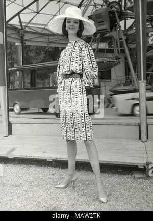 Modèle à partir de la soixantaine portant grand chapeau, gants longs, et robe à motifs, Italie Banque D'Images