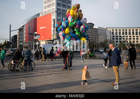 L'enfant joue en face d'un vendeur de ballons à la Potsdamer Platz, à Berlin, Allemagne. Banque D'Images