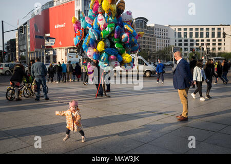 L'enfant joue en face d'un vendeur de ballons à la Potsdamer Platz, à Berlin, Allemagne. Banque D'Images