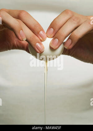 Fissuration mains un œuf ouvert Banque D'Images