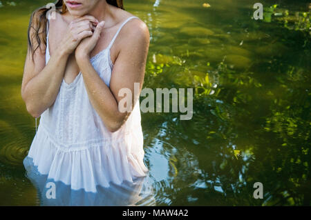 Une femme humide avec Poule debout dans l'eau.