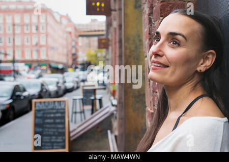 Une femme à la recherche sur un trottoir dans le quartier de South Street Seaport de New York. Banque D'Images