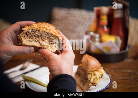 Burger Man eating in restaurant Banque D'Images