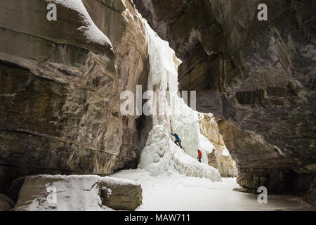 Male rock climber climbing ice mountain Banque D'Images