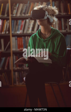 Femme à l'aide de casque de réalité virtuelle dans la bibliothèque Banque D'Images