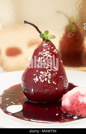 Les Poires au vin. Dessert traditionnel de compote de poires au vin rouge avec une sauce au vin sur plaque sur fond d'or. Vue d'en haut Banque D'Images