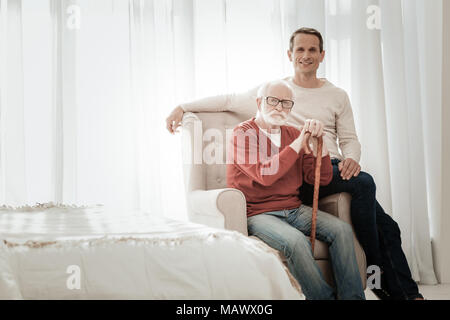 Inébranlable Senior homme assis sur la chaise et à la droite. Banque D'Images