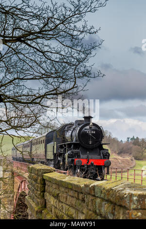 Vue avant de la vieille locomotive à vapeur britannique d'époque 43106 qui approche, puffant de la fumée, se déplaçant dans la campagne anglaise pittoresque au printemps. Banque D'Images