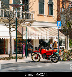 Moto Honda vintage rouge garée dehors un sweet shop à Lido, Venise, Italie Banque D'Images