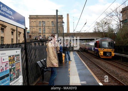 Un Northern Rail train approchant la station de Saltaire, un village modèle victorien, maintenant un site du patrimoine mondial Banque D'Images