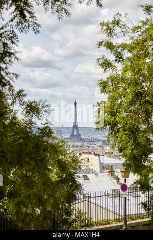 La Tour Eiffel vue depuis la Butte Montmartre, au milieu des arbres à la verticale. Banque D'Images