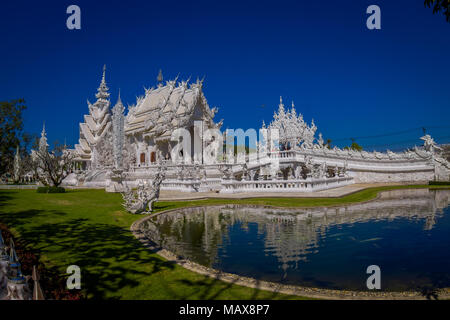 CHIANG RAI, THAÏLANDE - février 01, 2018 : des personnes non identifiées, à prendre des photos de white temple Wat Rong Khun situé dans le nord de Chiang Rai en Thaïlande en journée ensoleillée avec un étang naturel Banque D'Images